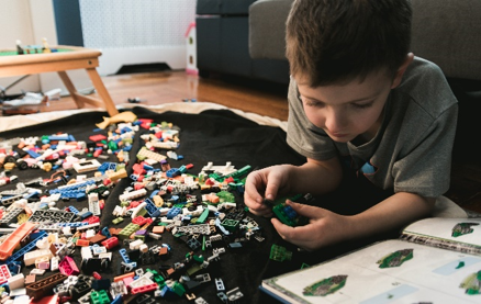 A young boy sitting at a table with a cakeDescription automatically generated